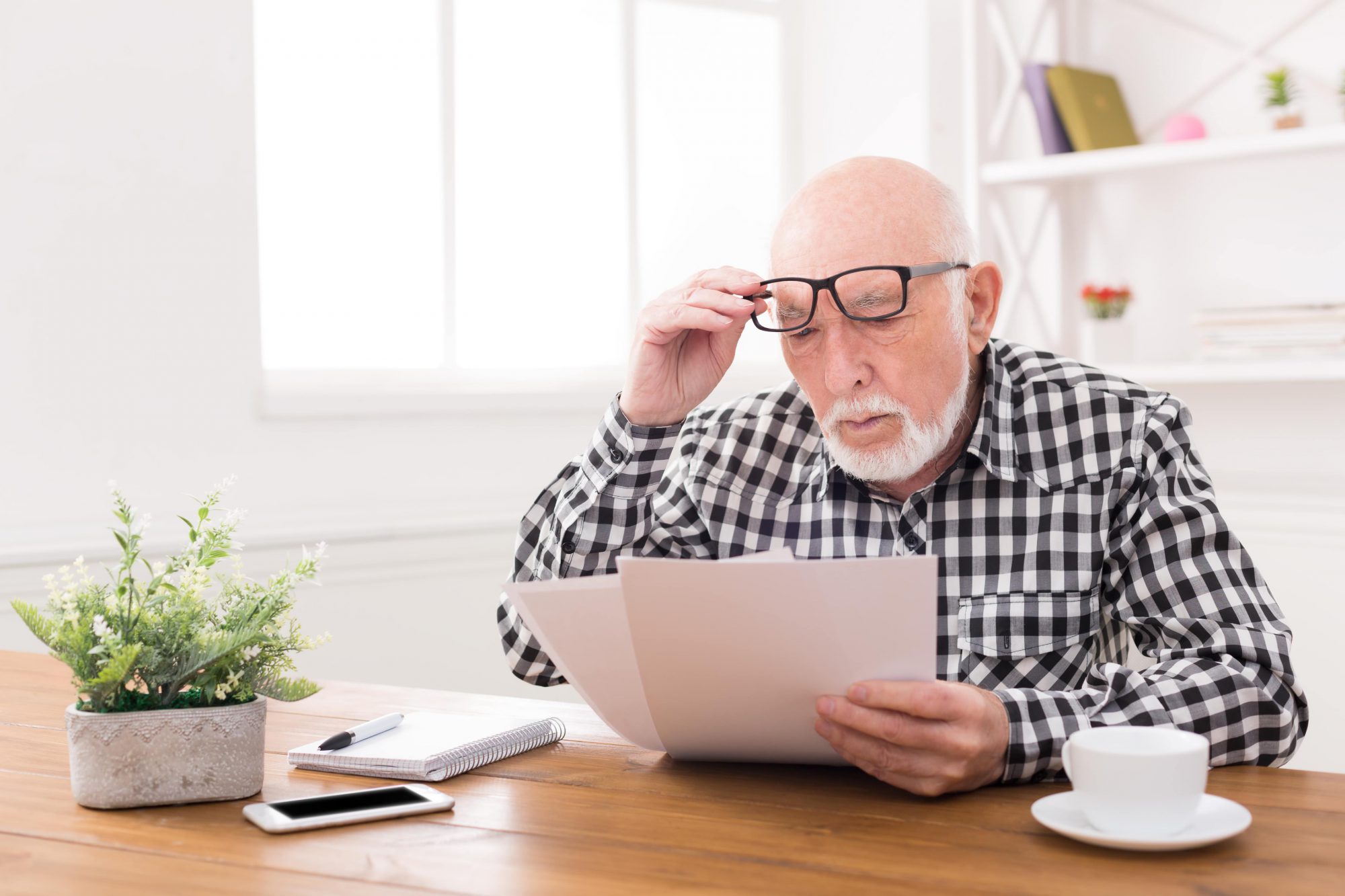 man having difficulty reading as his eyes age and he develops presbyopia